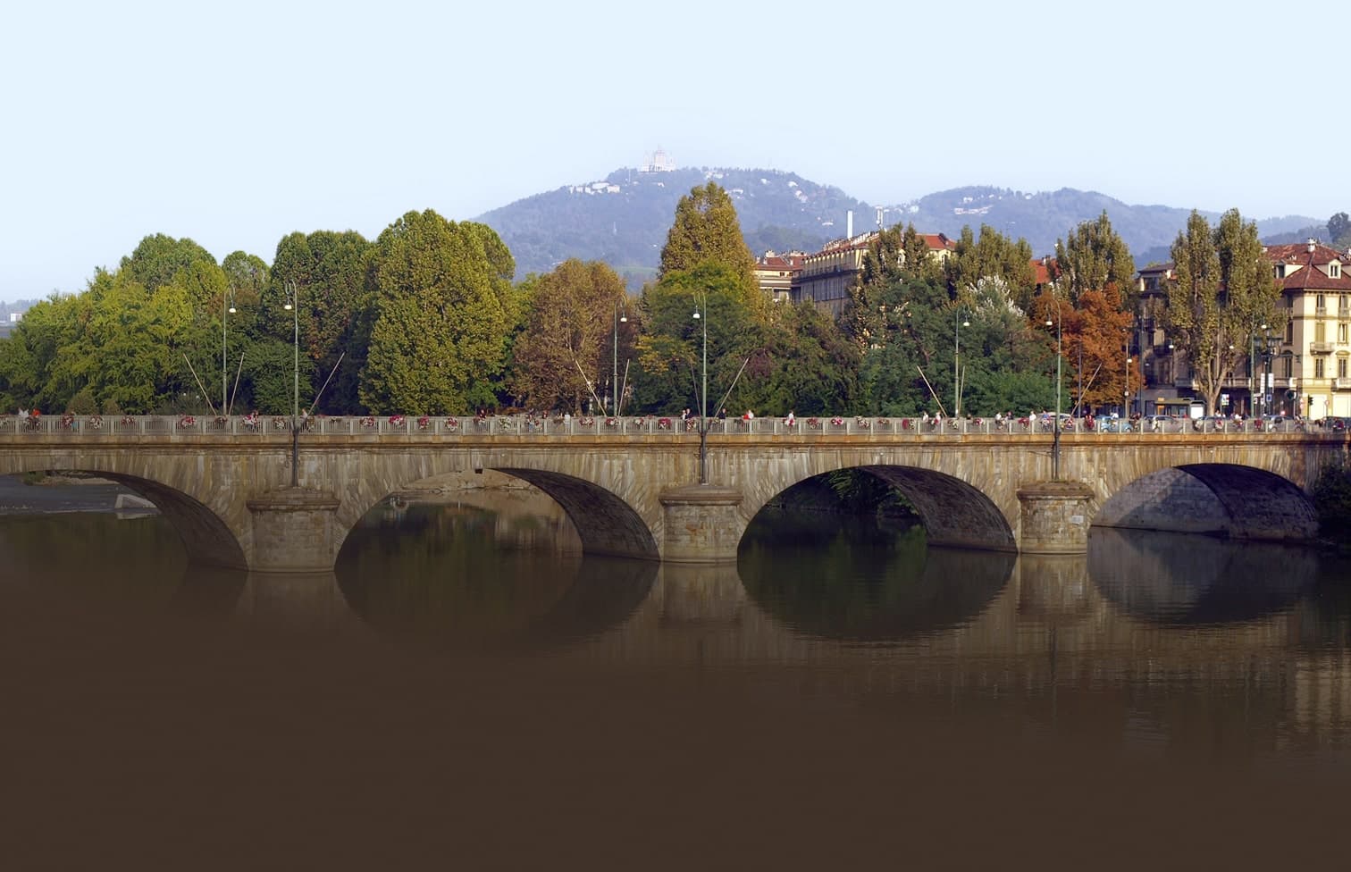 Ponte Vittorio Emanuele sul fiume Po a Torino con colline alberate sullo sfondo
