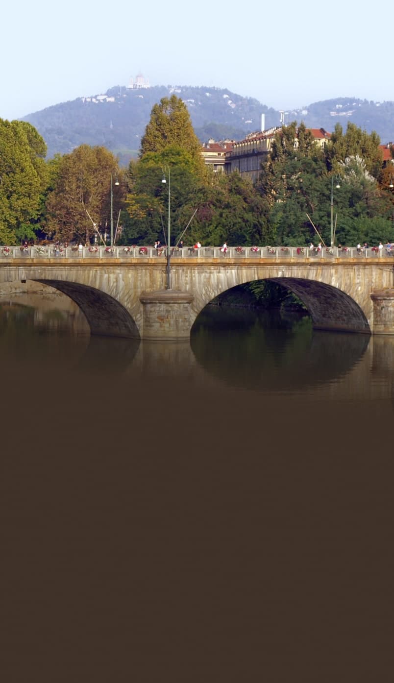 Ponte Vittorio Emanuele sul fiume Po a Torino con colline alberate sullo sfondo