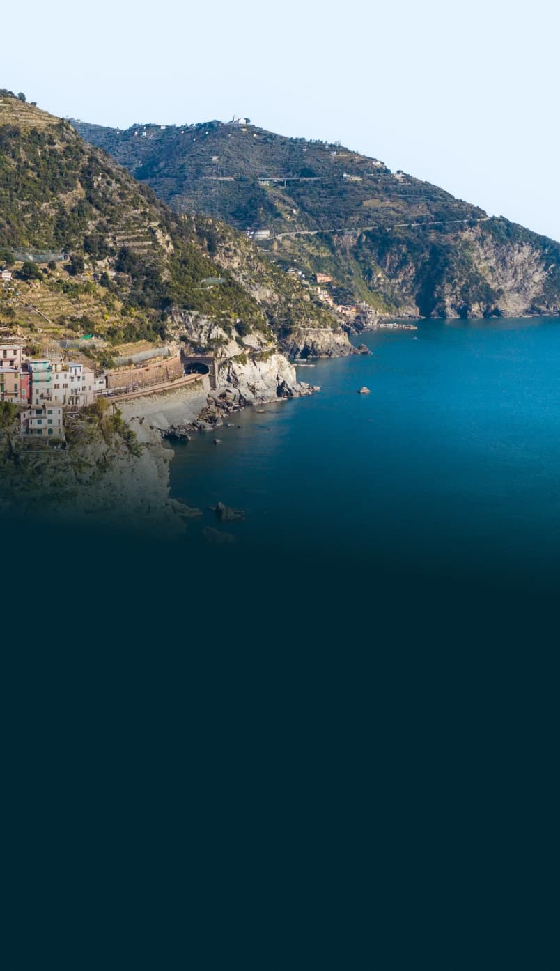 Scogliera rocciosa sul mare ligure con case affacciate