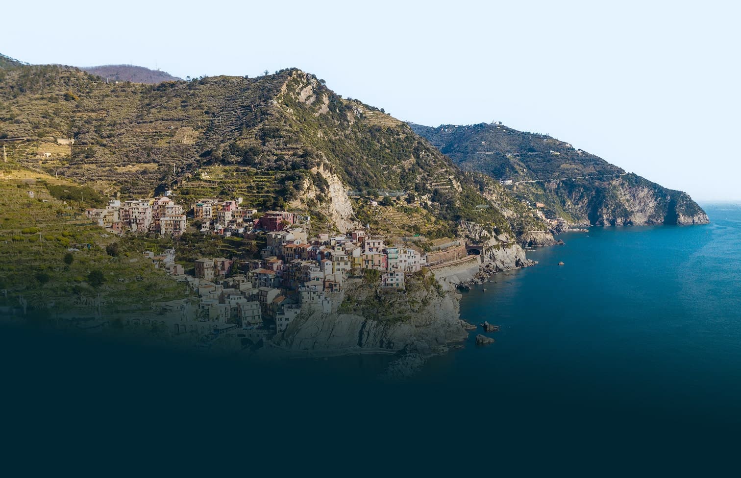 Scogliera rocciosa sul mare ligure con case affacciate